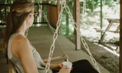 Frau sitzt im Hängesessel auf dem Kabinendeck