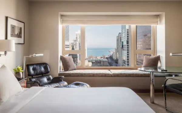 Hotelzimmer mit einem großen Fenster, das auf die Stadt hinausgeht.