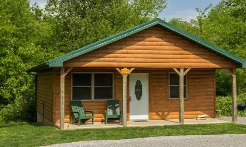 Das Äußere einer von Grün umgebenen Holzhütte