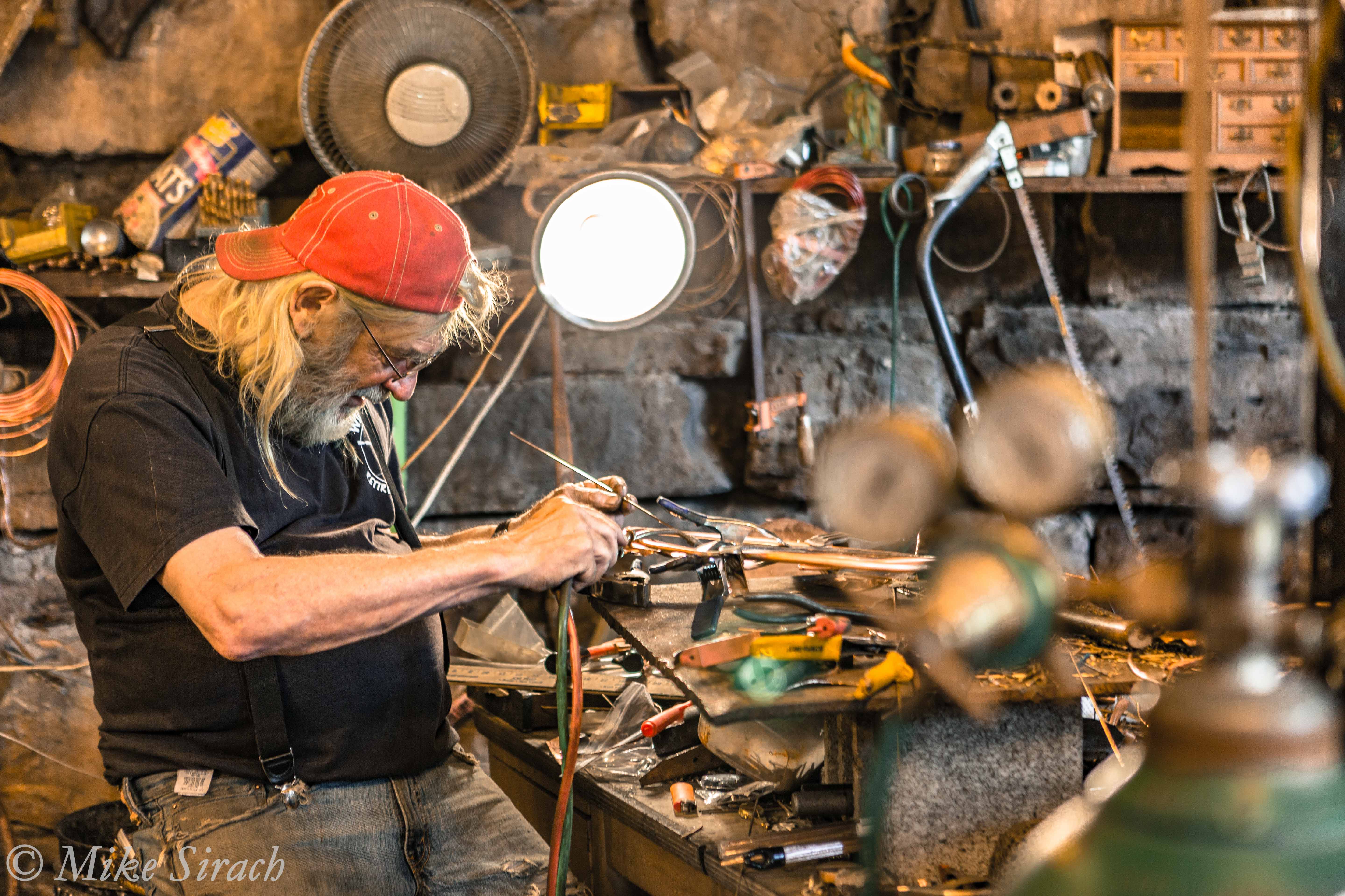 Ein Kunsthandwerker bei der Arbeit in der Werkstatt der Rain Maker Studios in Makanda