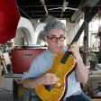 Ian Schneller klimpert auf einer Gitarre, die er selbst gebaut hat.
