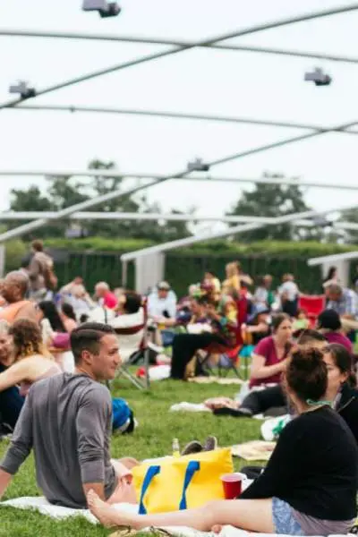 Ein großes Publikum sitzt auf dem Rasen vor dem Pritzker-Pavillon