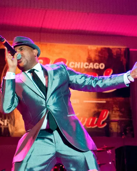 Ein Bluessänger im edlen Metallanzug auf der Bühne, der ein Lied anstimmt