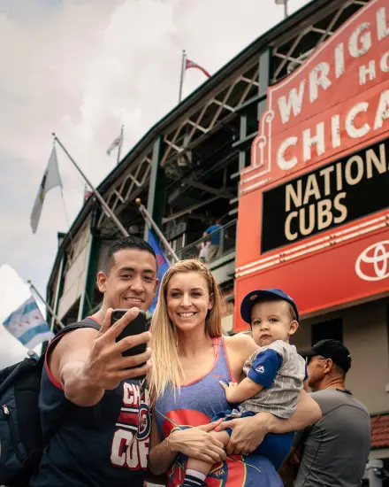 Familie posiert für ein Foto vor einem Stadion