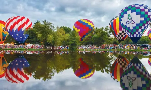 Heißluftballons umgeben einen See (Foto Don Burkett)