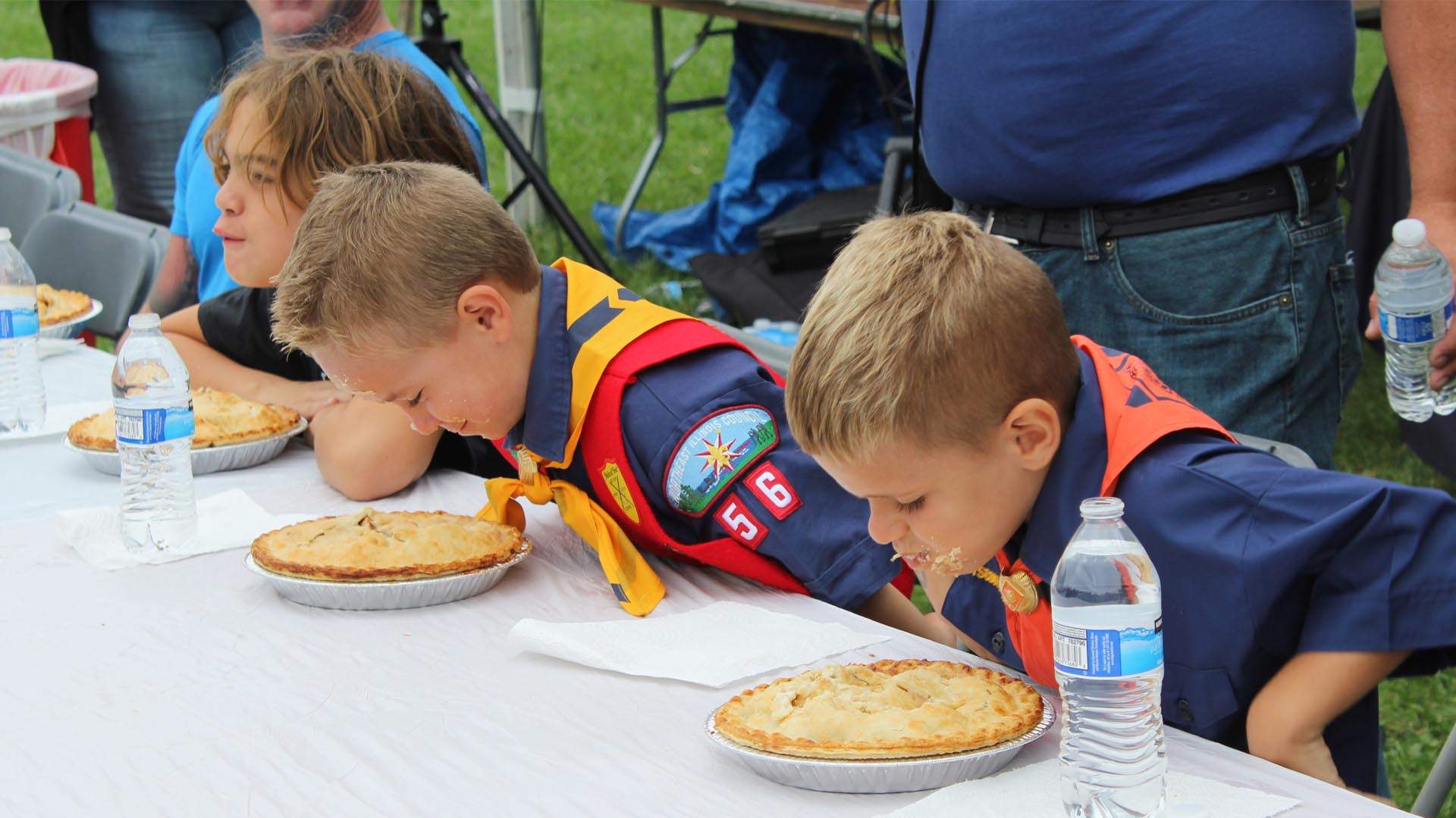 Jungen nehmen an einem Wettbewerb im Kuchenessen auf dem Long Grove Strawberry Fest teil