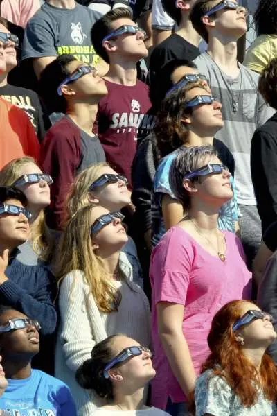 Menschen schauen während der Sonnenfinsternis in den Himmel