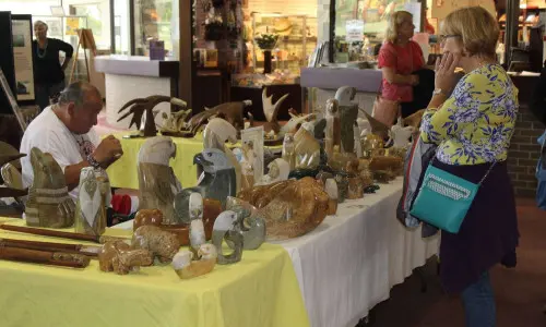 Eine Frau stöbert auf einem Weihnachtsmarkt in Kunstwerken
