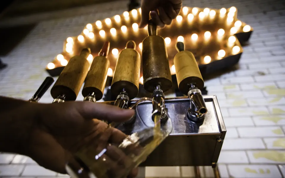 Person, die in der Old Bakery Beer ein gezapftes Bier in ein Glas gießt
