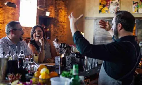 Barkeeper unterhält Kunden.