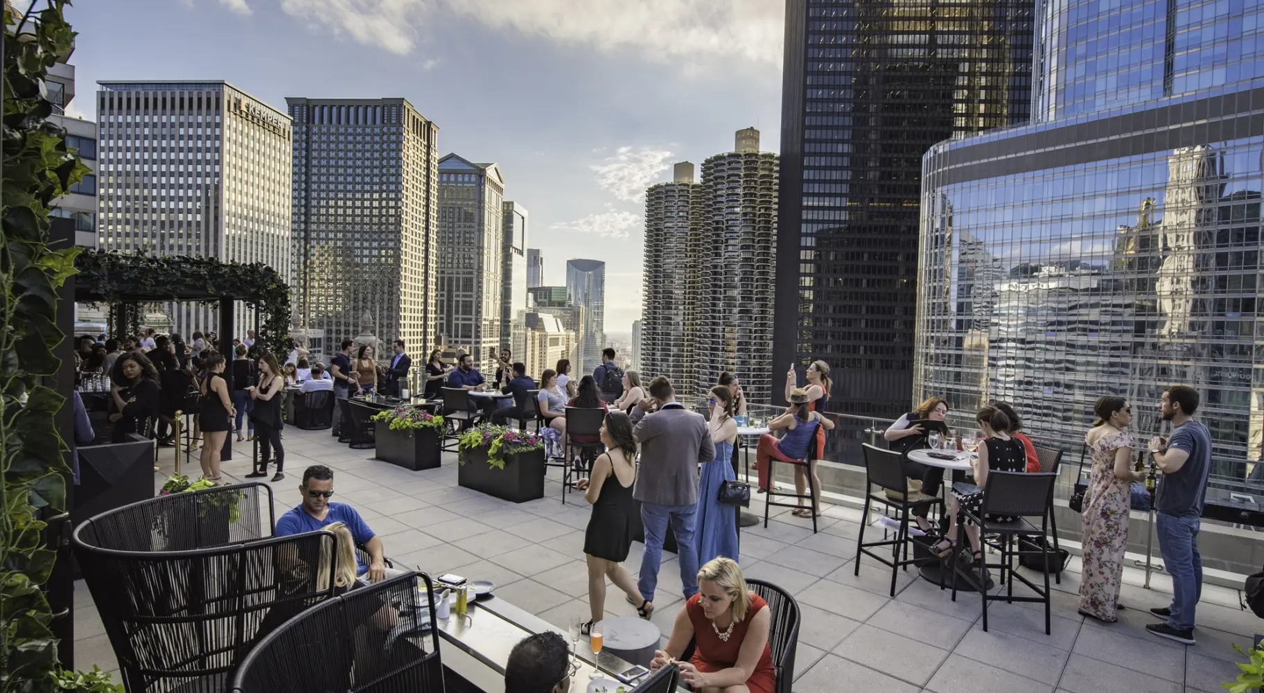 Menschen versammeln sich in einer Bar auf dem Dach inmitten von Wolkenkratzern