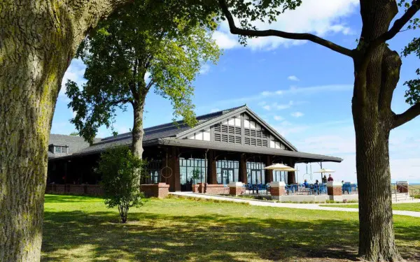 Das Äußere eines Restaurants am See mit Bäumen im Vordergrund 