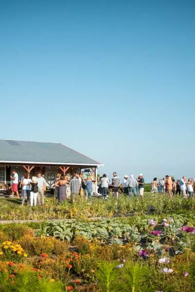 Versammelte Menschen, die vor dem Bauernhaus plaudern und trinken