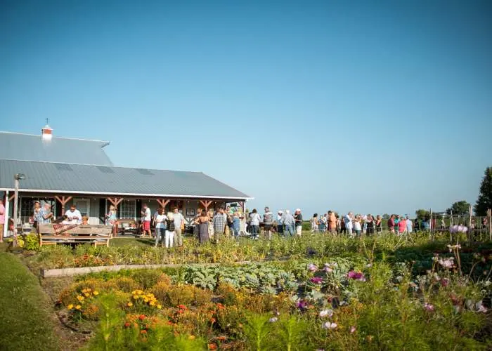 Versammelte Menschen, die vor dem Bauernhaus plaudern und trinken