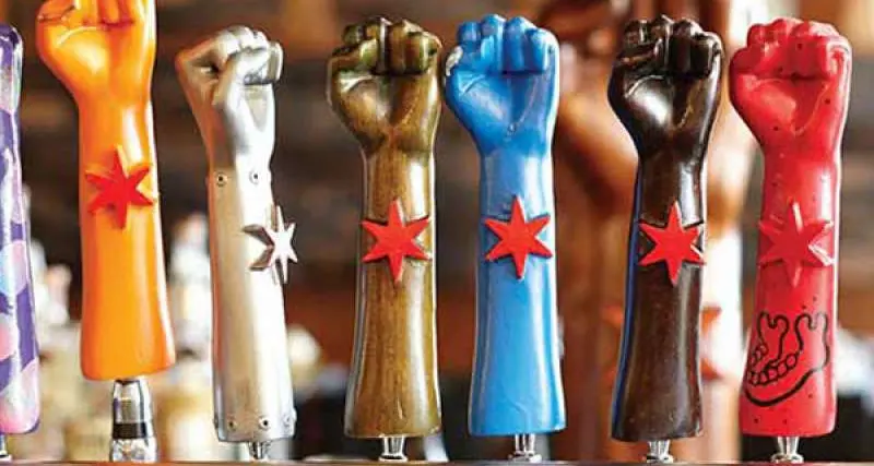 Eine Reihe von sieben Revolution Brewing Bierzapfhähnen in Form von Fäusten 