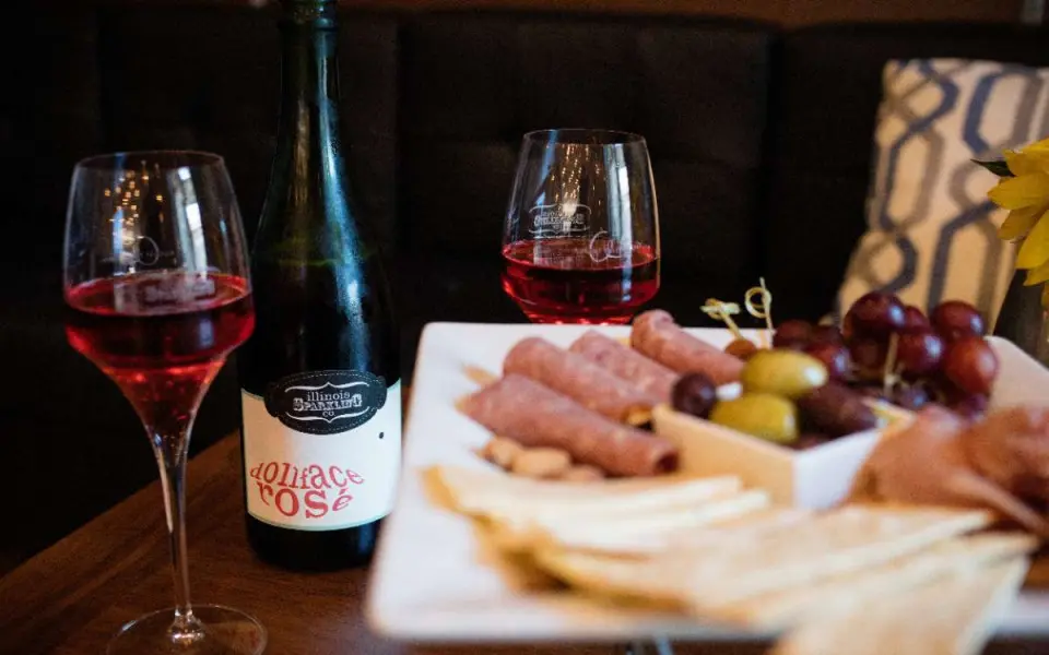 Eine Käseplatte und ein paar Gläser Wein stehen auf einem Tisch