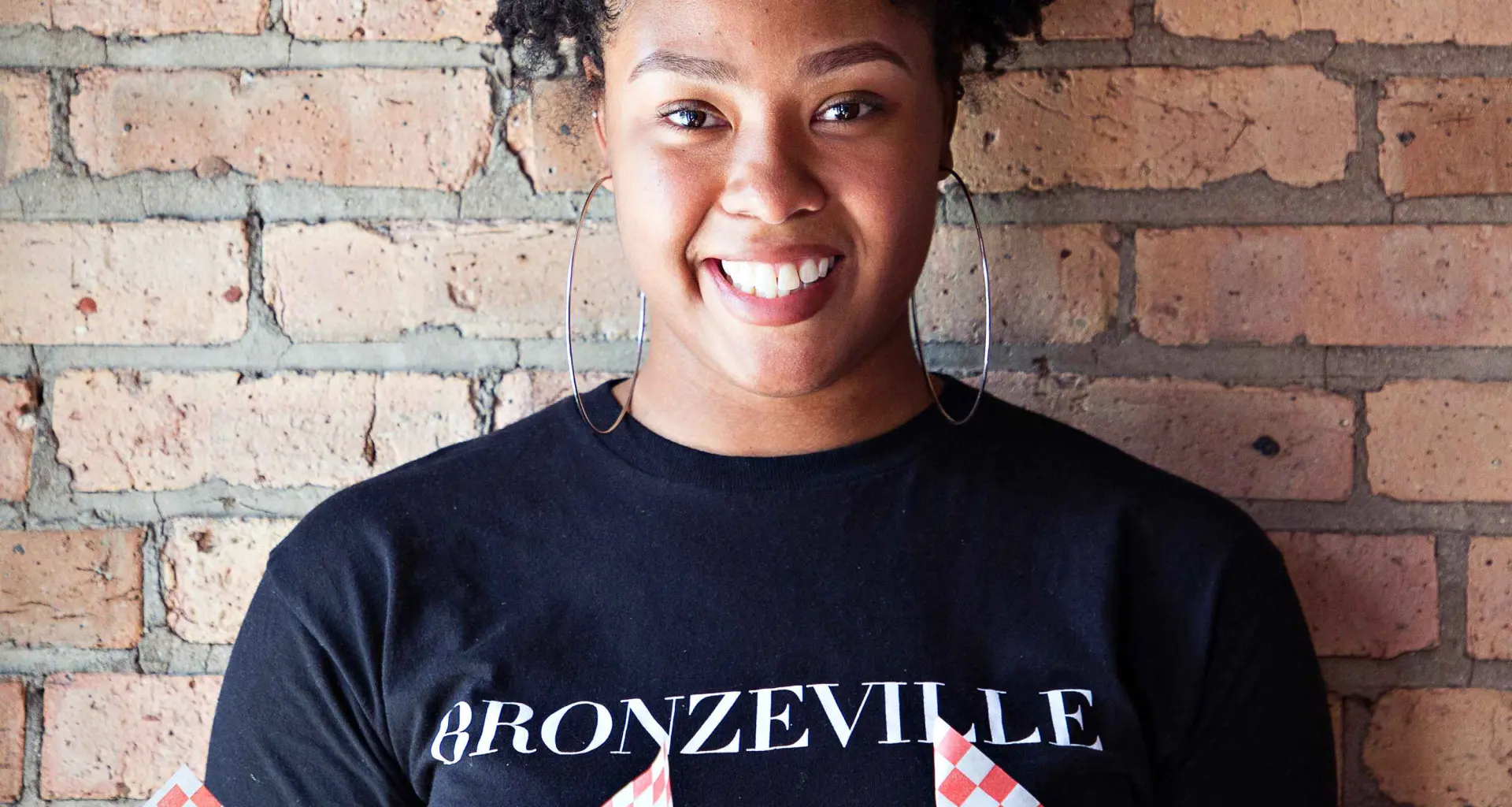 Frau hält Essen vor einer Backsteinmauer