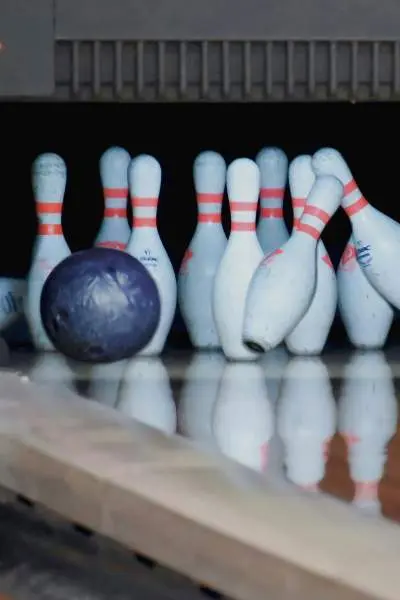 Bowlingkugeln prallen auf Kegel auf einer Bowlingbahn