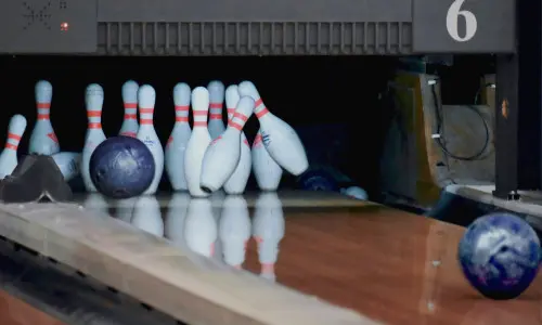 Bowlingkugeln prallen auf Kegel auf einer Bowlingbahn