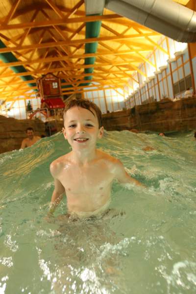 Lächelnder Junge in einem Wellenbad.