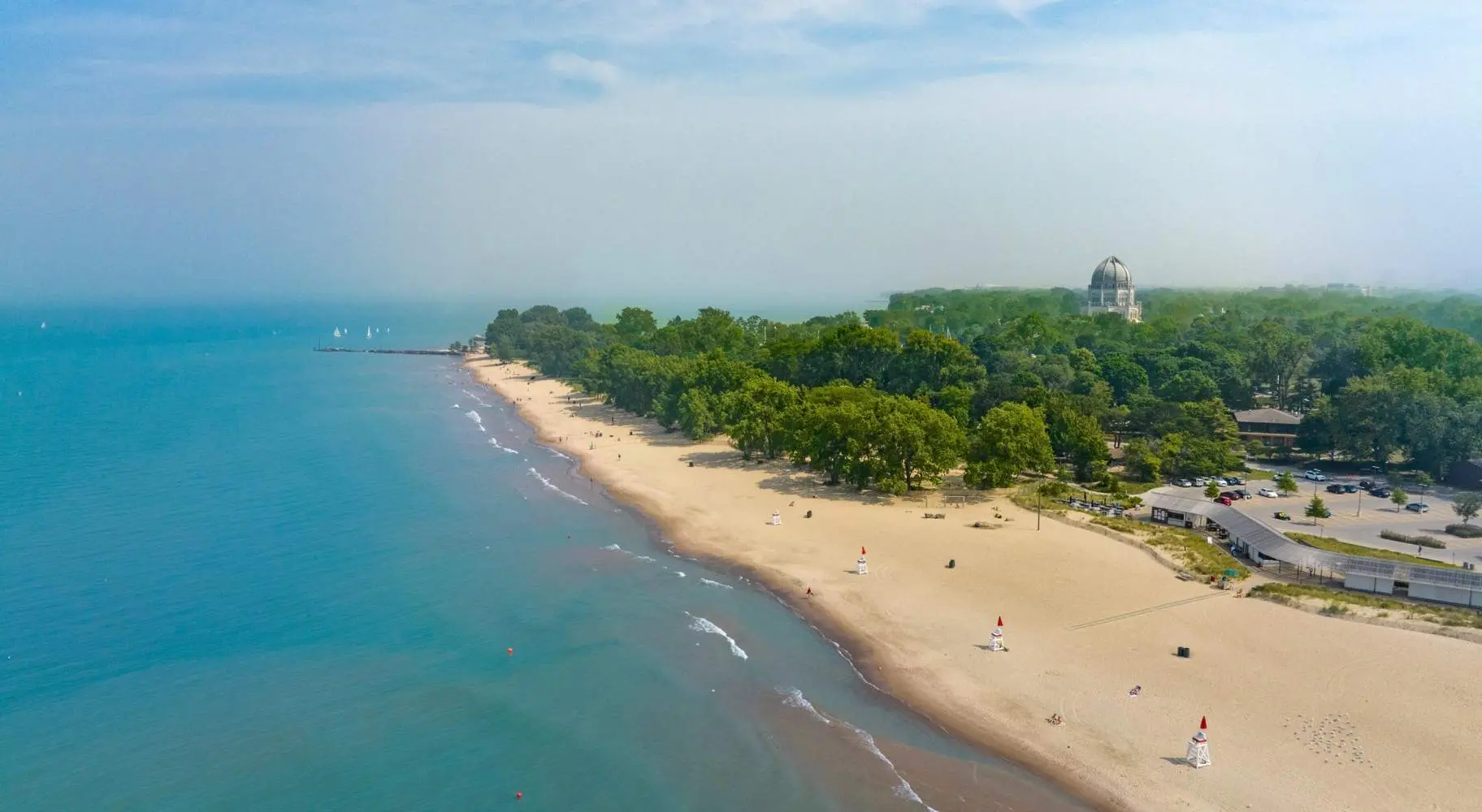 Luftaufnahme einer Strandküste mit grünen Bäumen im Hintergrund