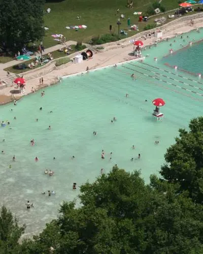 Luftaufnahme eines aufgefüllten Steinbruchstrandes, mit Menschen im Wasser und am Ufer