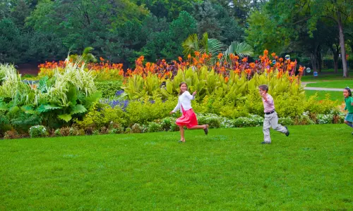 Zwei Kinder laufen über das Gras