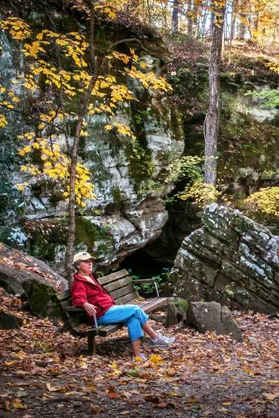 Person sitzt auf einer Bank im Wald