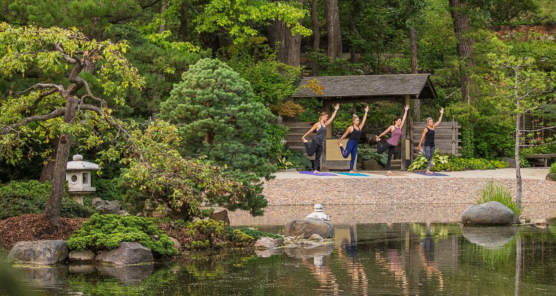 Menschen beim Yoga am Seeufer