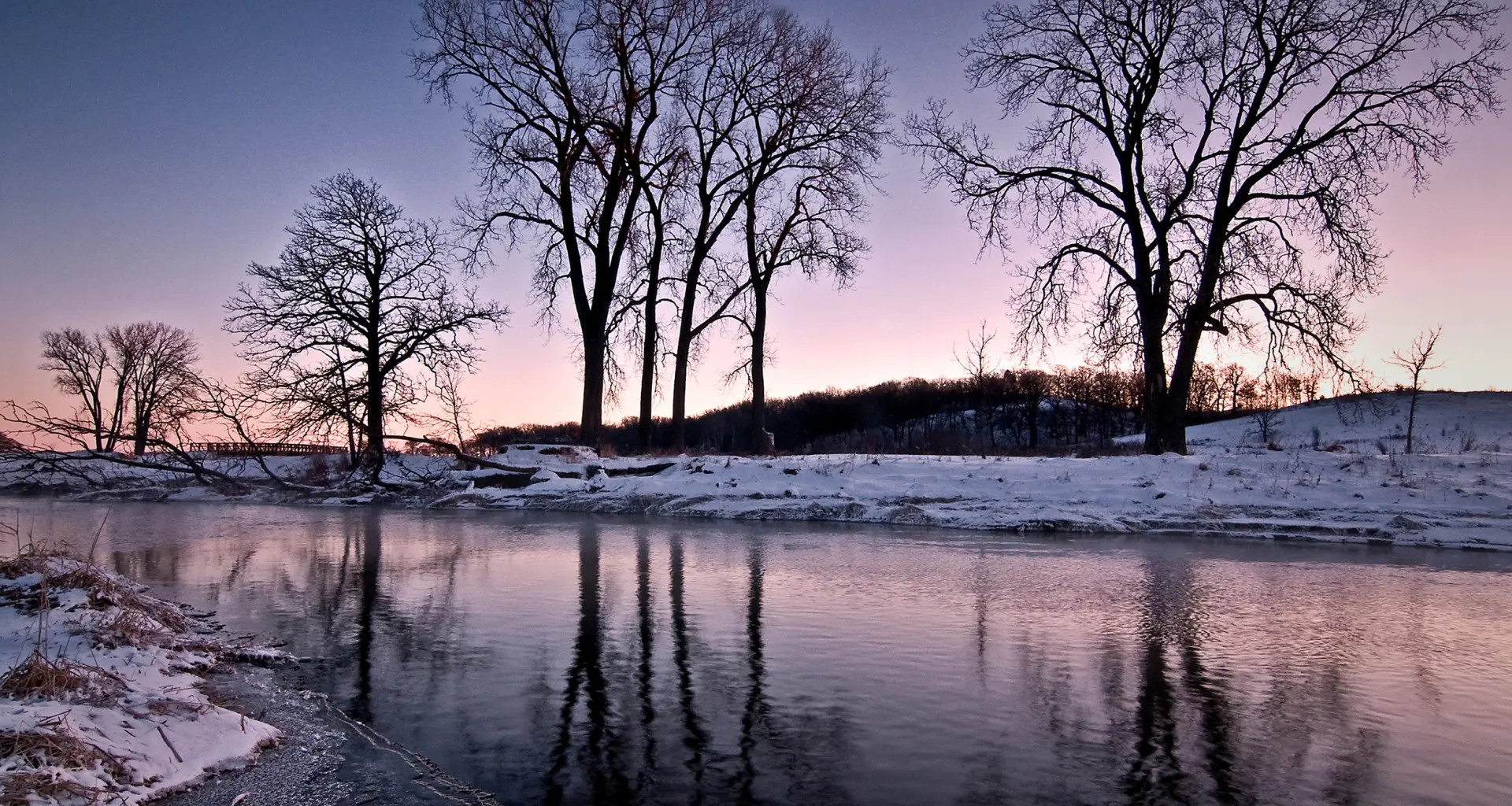 Die schneebedeckten Ufer des Nippersink Creek in der Abenddämmerung, im Glacial Park, McHenry County