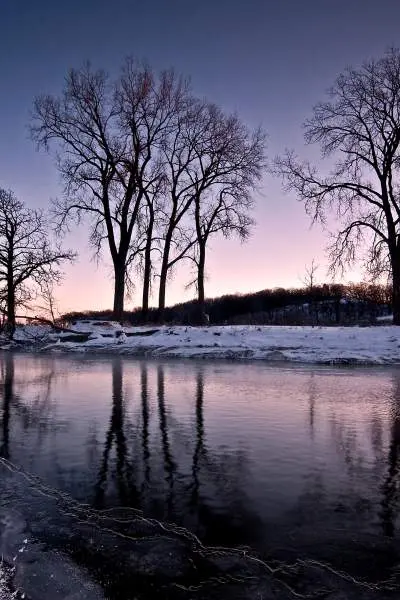 Die schneebedeckten Ufer des Nippersink Creek in der Abenddämmerung, im Glacial Park, McHenry County