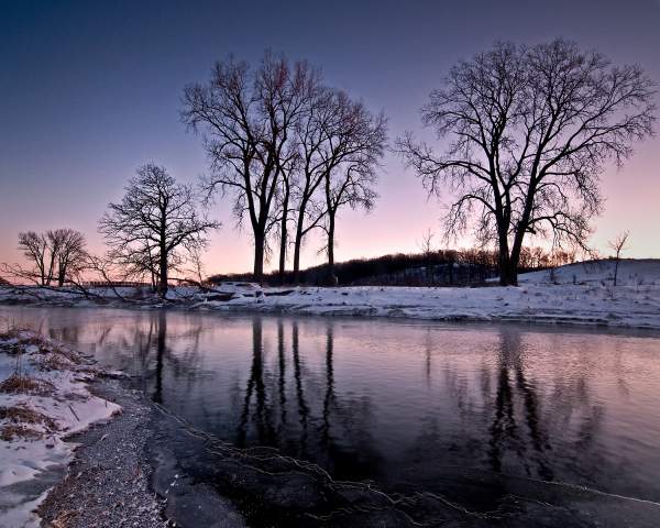 Die schneebedeckten Ufer des Nippersink Creek in der Abenddämmerung, im Glacial Park, McHenry County