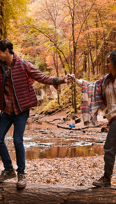 Ein Ehepaar wandert im Herbst durch den Wald.