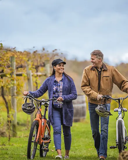 Ein Paar, das mit seinen Fahrrädern durch die Weinberge fährt