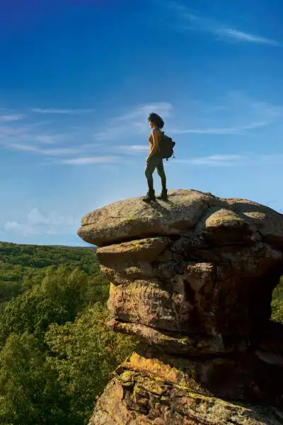 Wanderer auf dem Garden of the Gods Camel Rock mit Blick auf den Wald.