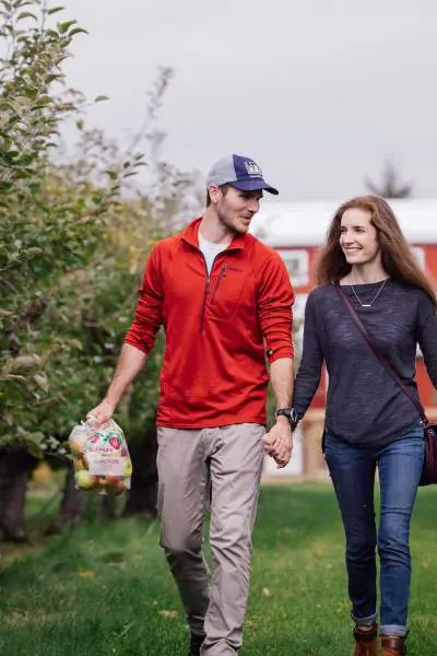 Ein Paar geht den Jonamac Orchard entlang.