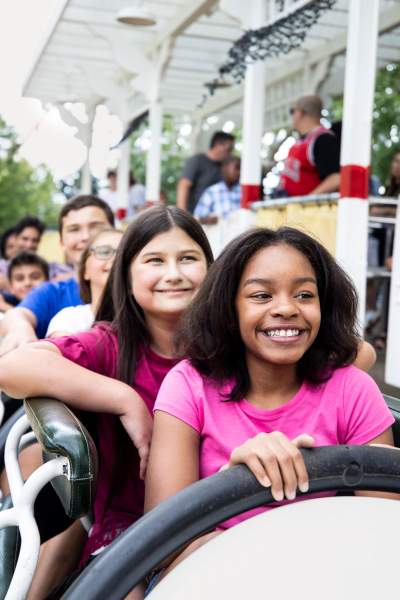 Kinder auf einer Fahrt im Vergnügungspark Six Flags.