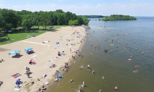 Eine Luftaufnahme eines Strandes mit Menschen, die Sonne, Sand und Wasser genießen