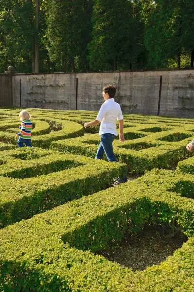 Menschen, die durch einen Labyrinthgarten gehen