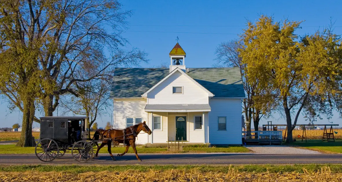Pferdekutsche fährt an einem Amish-Gebäude vorbei 