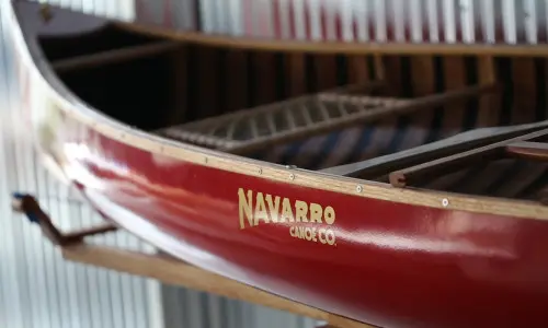 Ein rotes Kanu mit dem Logo von Navarro Canoe.
