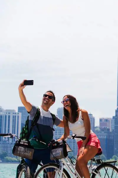 Ein Paar fährt Fahrrad und macht ein Foto am Seeufer von Chicago