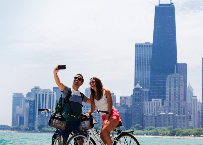 Ein Paar fährt Fahrrad und macht ein Foto am Seeufer von Chicago