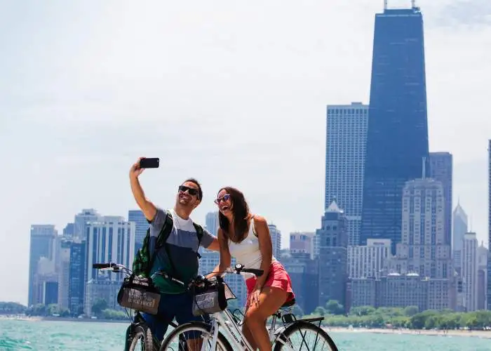 Ein Paar fährt Fahrrad und macht ein Foto am Seeufer von Chicago