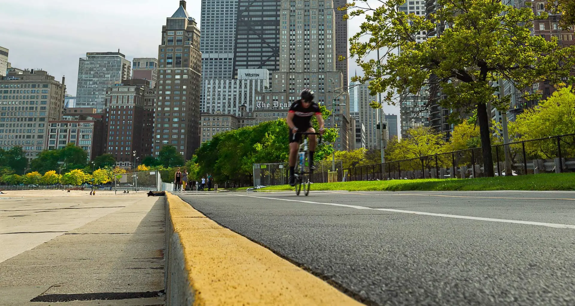 Rennradfahrer auf dem Radweg am Seeufer in Chicago mit der Stadt im Hintergrund