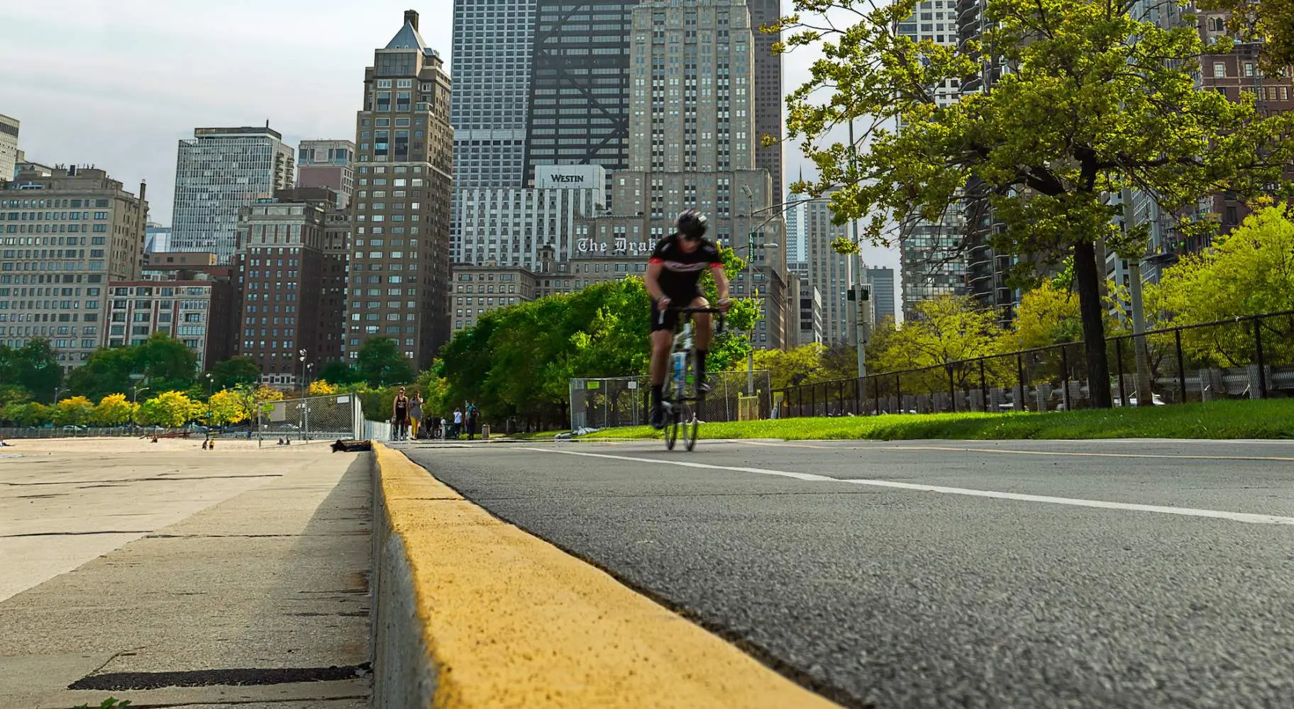 Rennradfahrer auf dem Radweg am Seeufer in Chicago mit der Stadt im Hintergrund