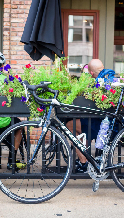 Radfahrer trinken einen Kaffee und ihre Fahrräder sind vor dem Café geparkt.