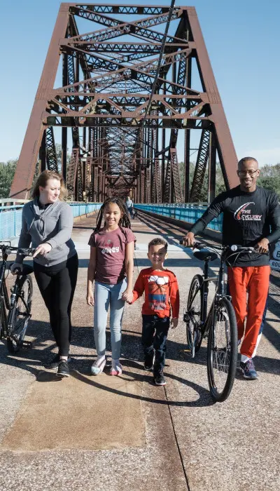 Familie mit Fahrrädern auf einer Brücke