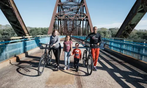 Familie mit Fahrrädern auf einer Brücke