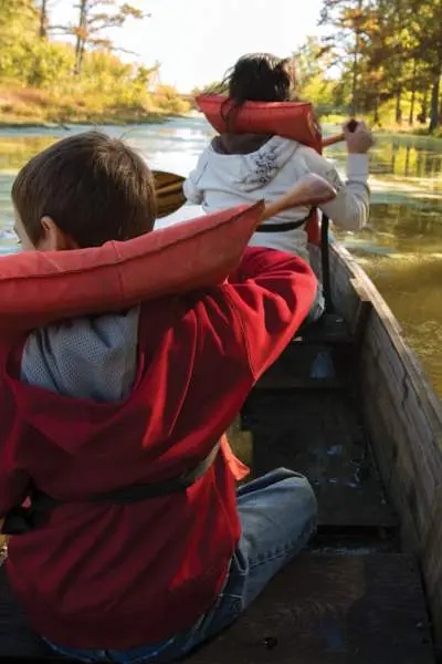 Eine Familie mit Schwimmwesten beim Kanufahren auf einem Fluss